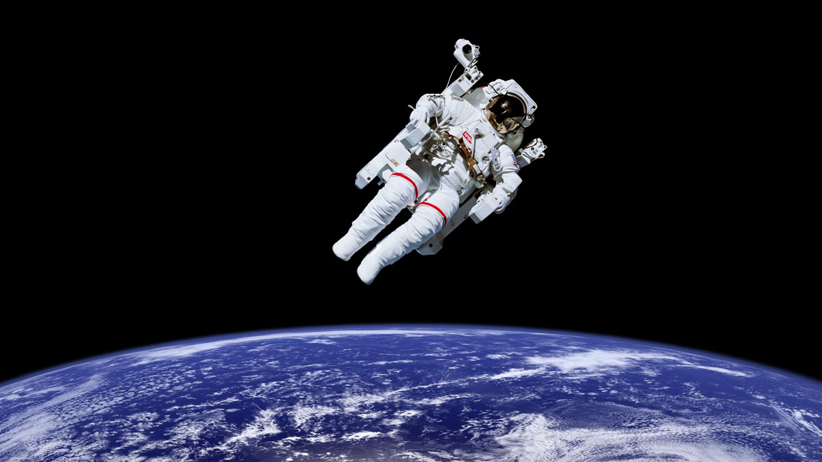 Astronaut space walking above earth